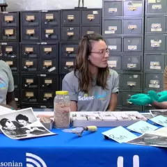 Emmanuel Kyei-Baffour, Maggy Benson and Molly Kampf seated at a table in a room full of card files and several specimens pictures and tools on the table.