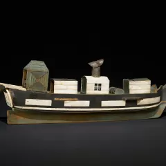 Painted wooden model of a steam ship with several structures on its deck.