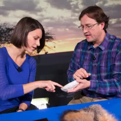 Maggy Benson and Dr. Torben Rick are seated at a table with several furry specimens in front of them.