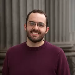 Bearded man standing in front of columns