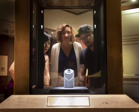 Three people look through display glass at the Hope Diamond.