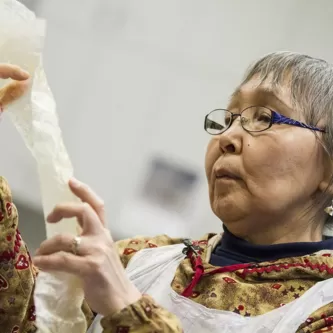 Woman inspecting piece of gutskin