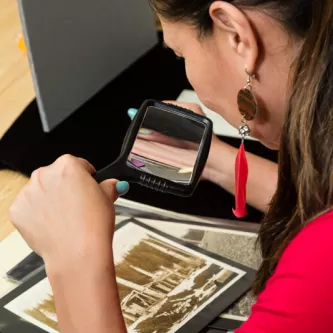 Researcher looking at historic photograph at the National Anthropological Archives