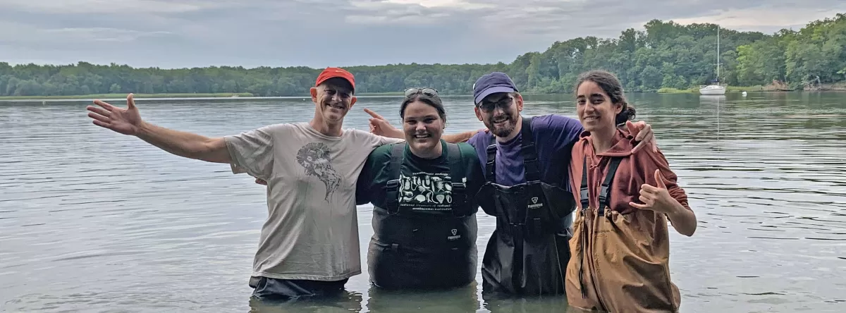 4 people posing in front of an ocean